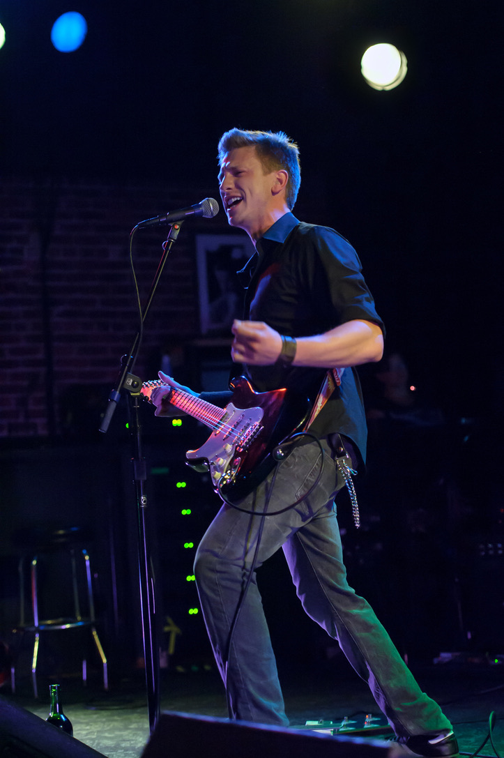 David Hadley singing and playing electric guitar on stage